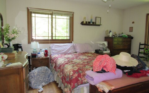 Overcome with furniture and belongings, this master bedroom lacks a feeling of relaxation and luxury.